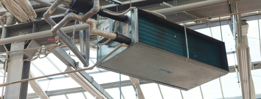 Unidad de climatización suspendida en un techo industrial