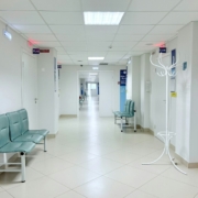 Pasillo de clínica con bancos y puertas